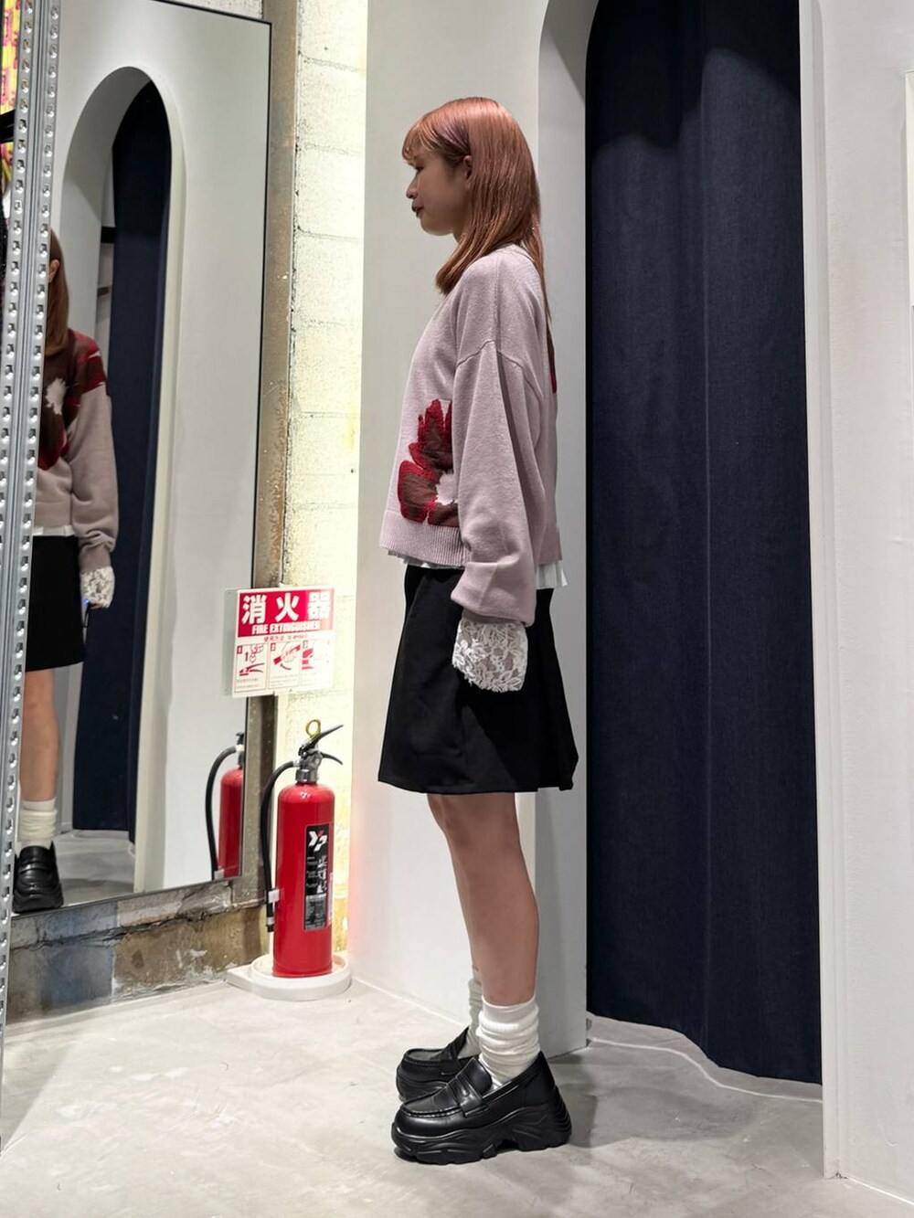 ホワイト系のTシャツ/カットソー、ピンク系のニット/セーター、ブラック系のスカートを着用したレディースの秋コーディネートの4枚目の写真