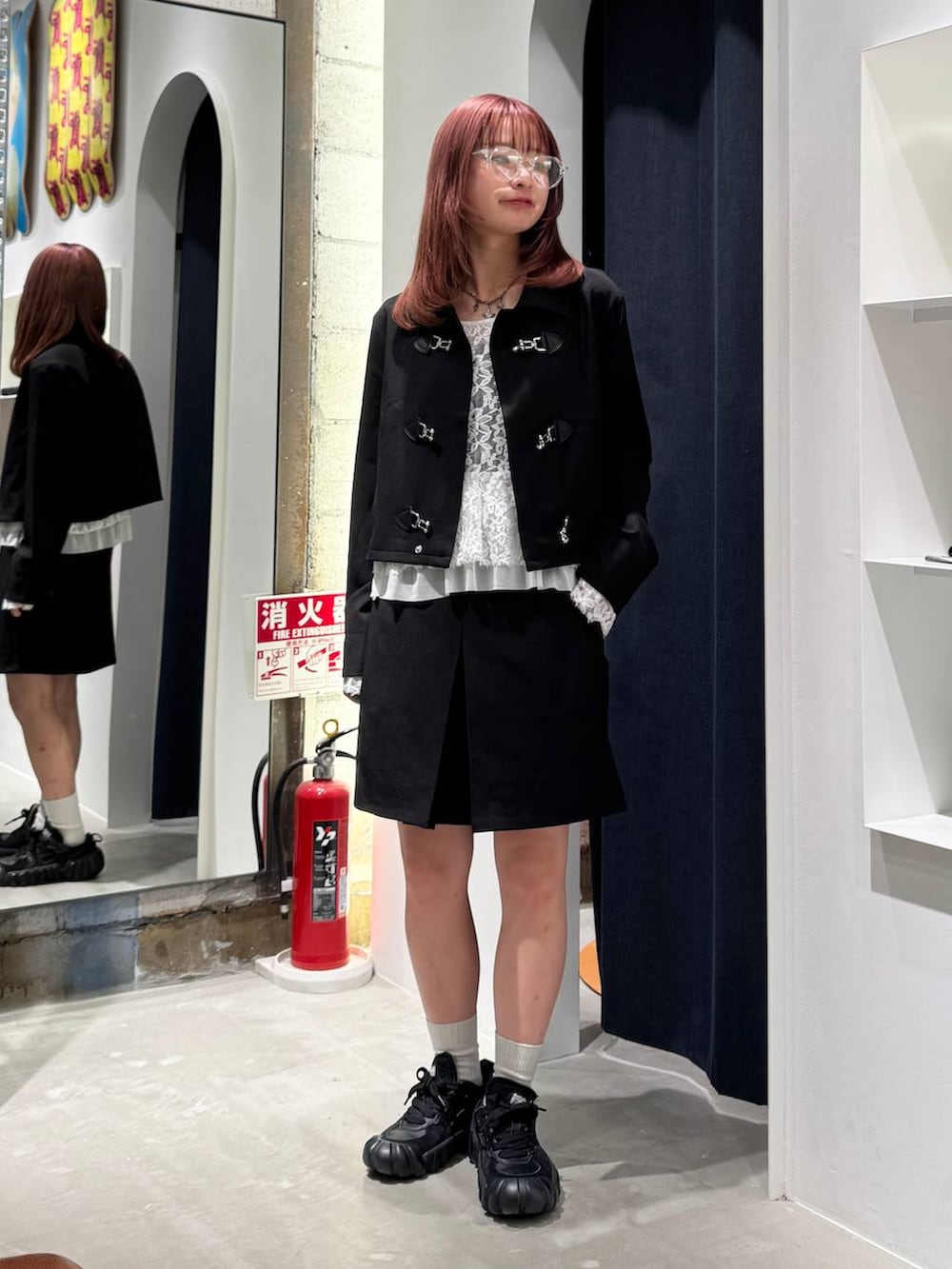 ホワイト系のTシャツ/カットソー、ブラック系のブルゾン、ブラック系のスカートを着用したレディースの秋コーディネートの4枚目の写真