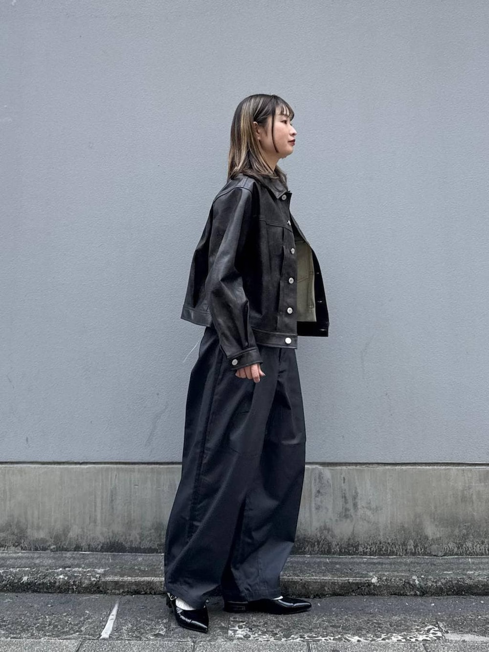 グレー系のチノパンツ、レッド系のパンプス、ブラウン系のブルゾンを着用したレディースの春コーディネートの8枚目の写真