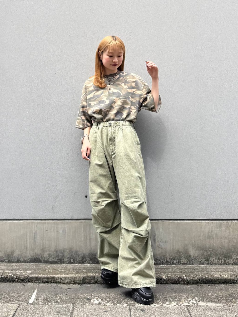 ブラック系のローファー、グリーン系のカーゴパンツ、ブラウン系のTシャツ/カットソーを着用したレディースの春コーディネートの2枚目の写真