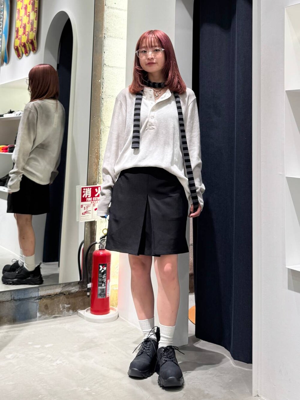 ブラック系のブーツ、ホワイト系のTシャツ/カットソー、ブラック系のニット/セーターを着用したレディースの秋コーディネートの4枚目の写真