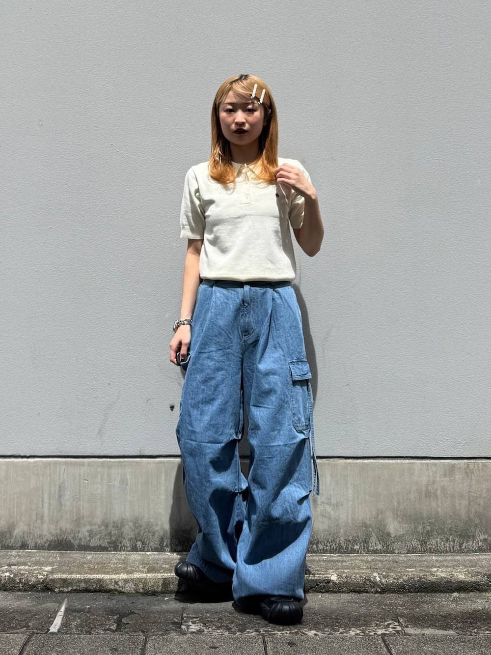 ブルー系のデニムパンツ、ホワイト系のポロシャツを着用したレディースの春コーディネートの2枚目の写真