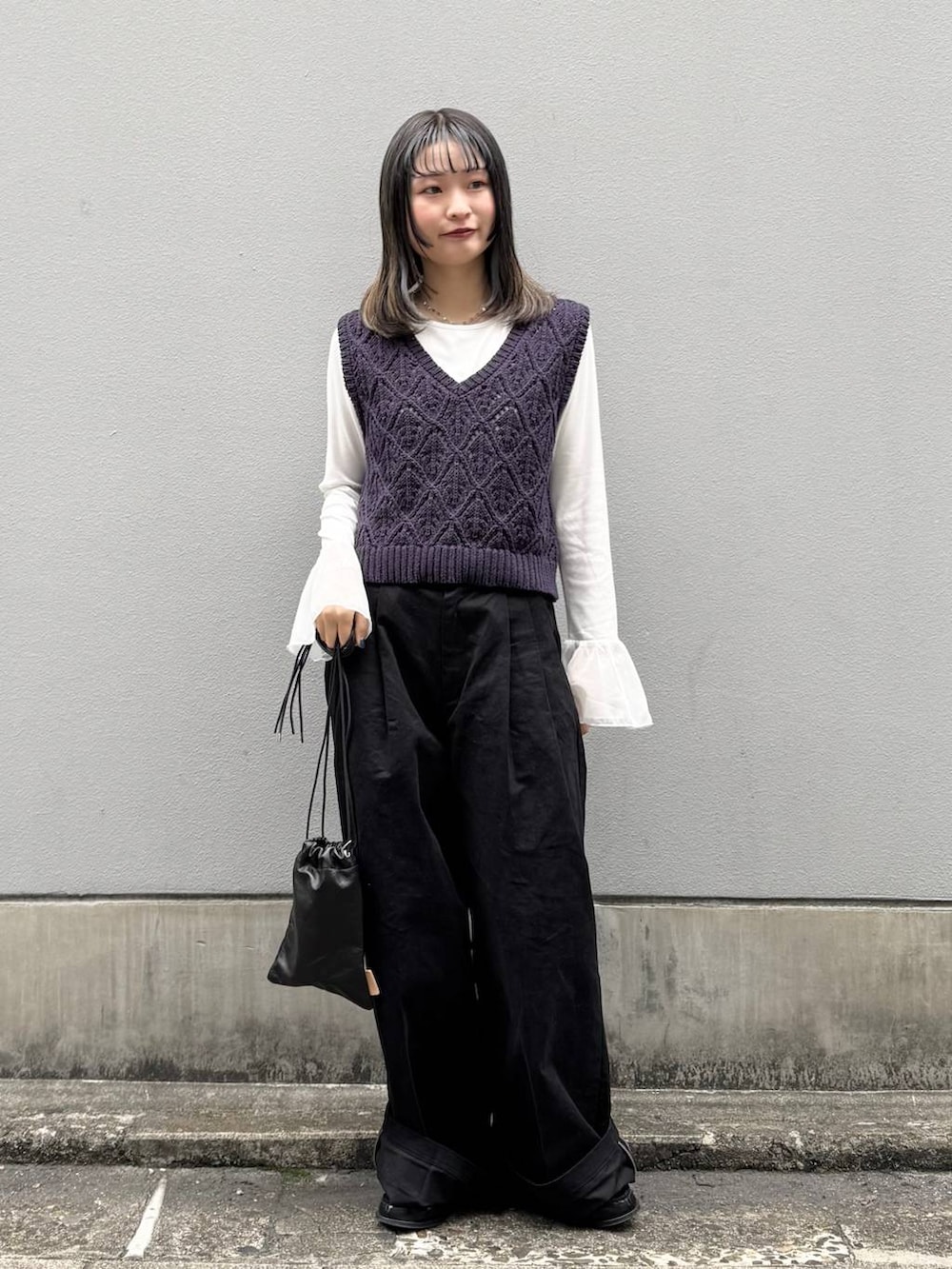 ブラック系のショルダーバッグ、ブラック系のチノパンツ、ホワイト系のTシャツ/カットソーを着用したレディースの春コーディネートの3枚目の写真