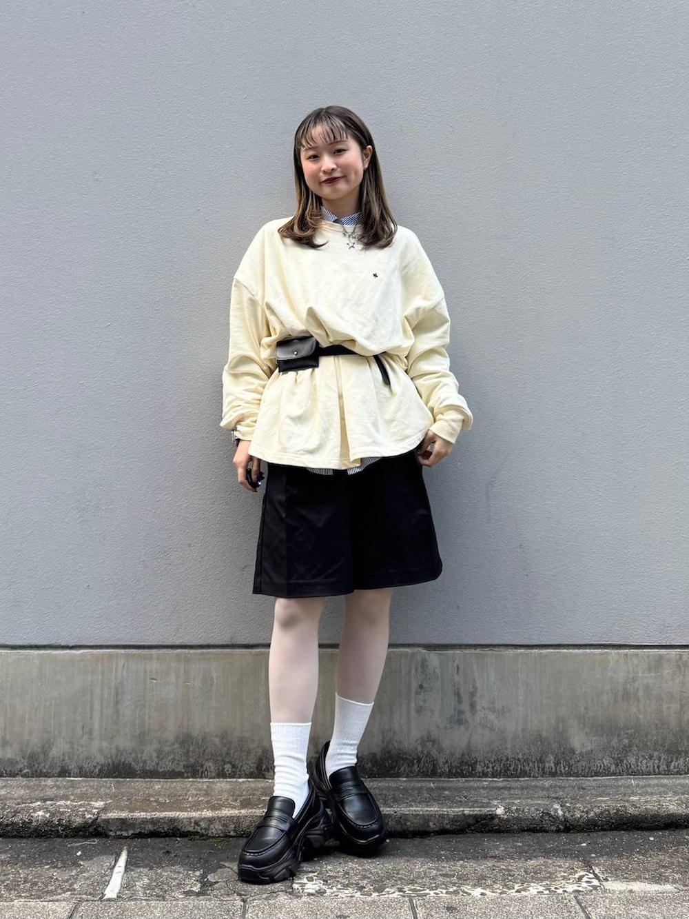 ブラック系のローファー、ブラック系のスラックス、ブルー系のシャツ/ブラウスを着用したレディースの春コーディネートの2枚目の写真