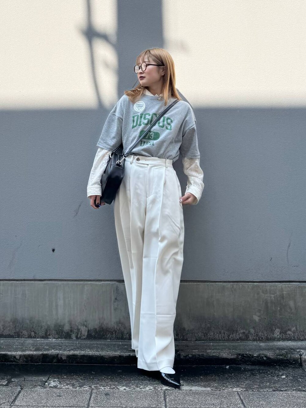 グレー系のTシャツ/カットソー、ブラック系のパンプス、ホワイト系のシャツ/ブラウスを着用したレディースの春コーディネートの2枚目の写真