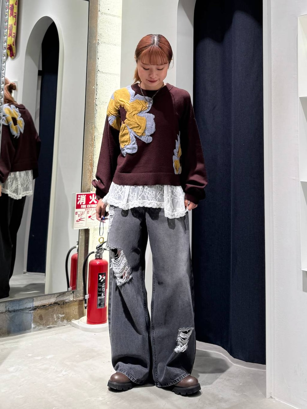 ホワイト系のTシャツ/カットソー、ブラウン系のニット/セーター、ブラック系のデニムパンツを着用したレディースの秋コーディネートの2枚目の写真
