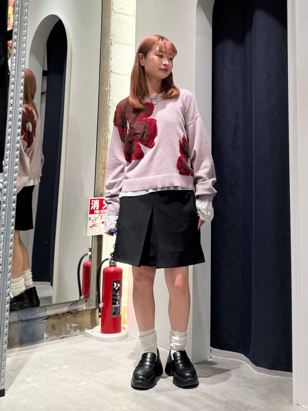 ホワイト系のTシャツ/カットソー、ピンク系のニット/セーター、ブラック系のスカートを着用したレディースの秋コーディネートの3枚目の写真
