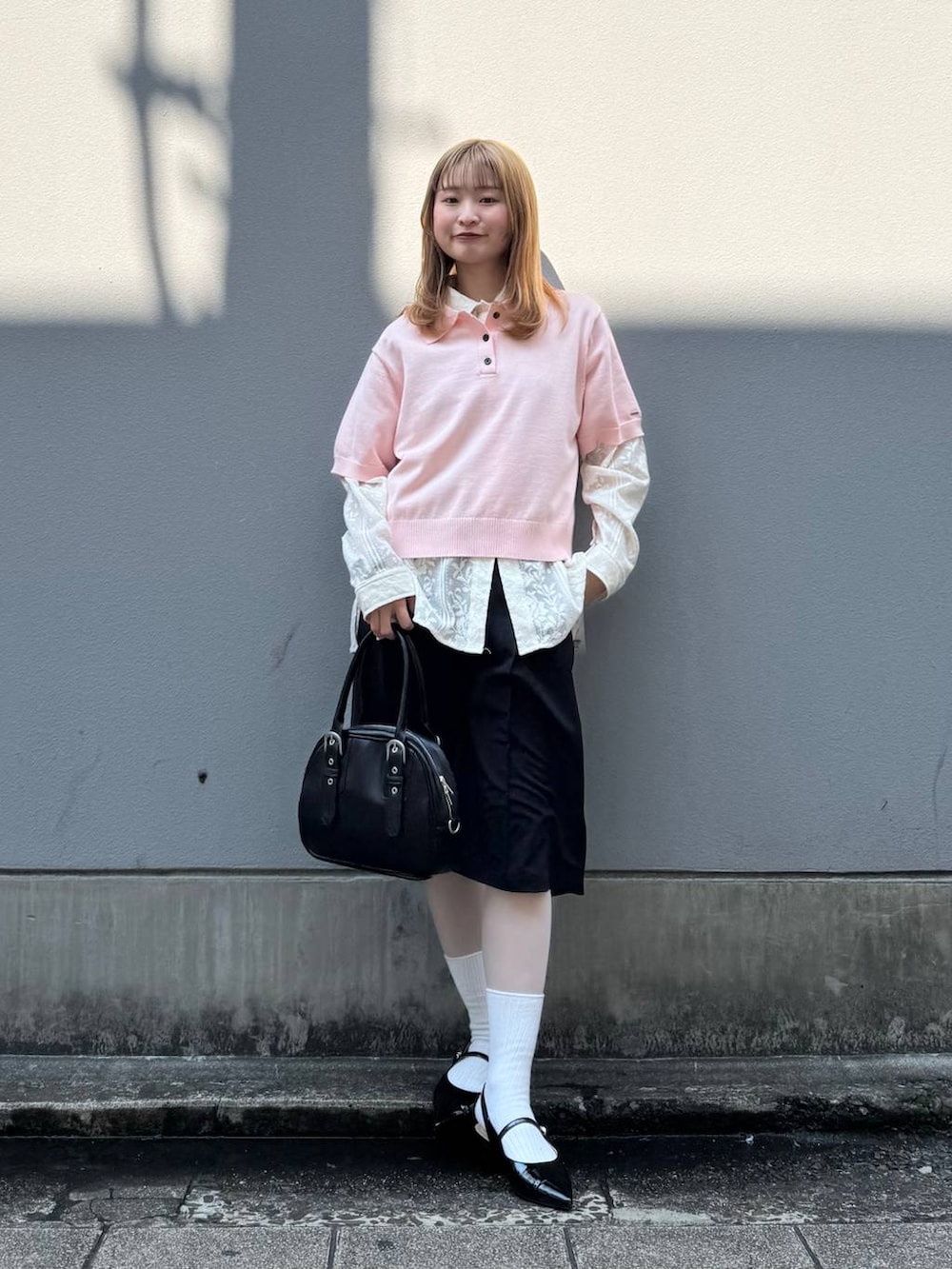 ブラック系のパンプス、ホワイト系のシャツ/ブラウス、ブラック系のスラックスを着用したレディースの春コーディネートの2枚目の写真