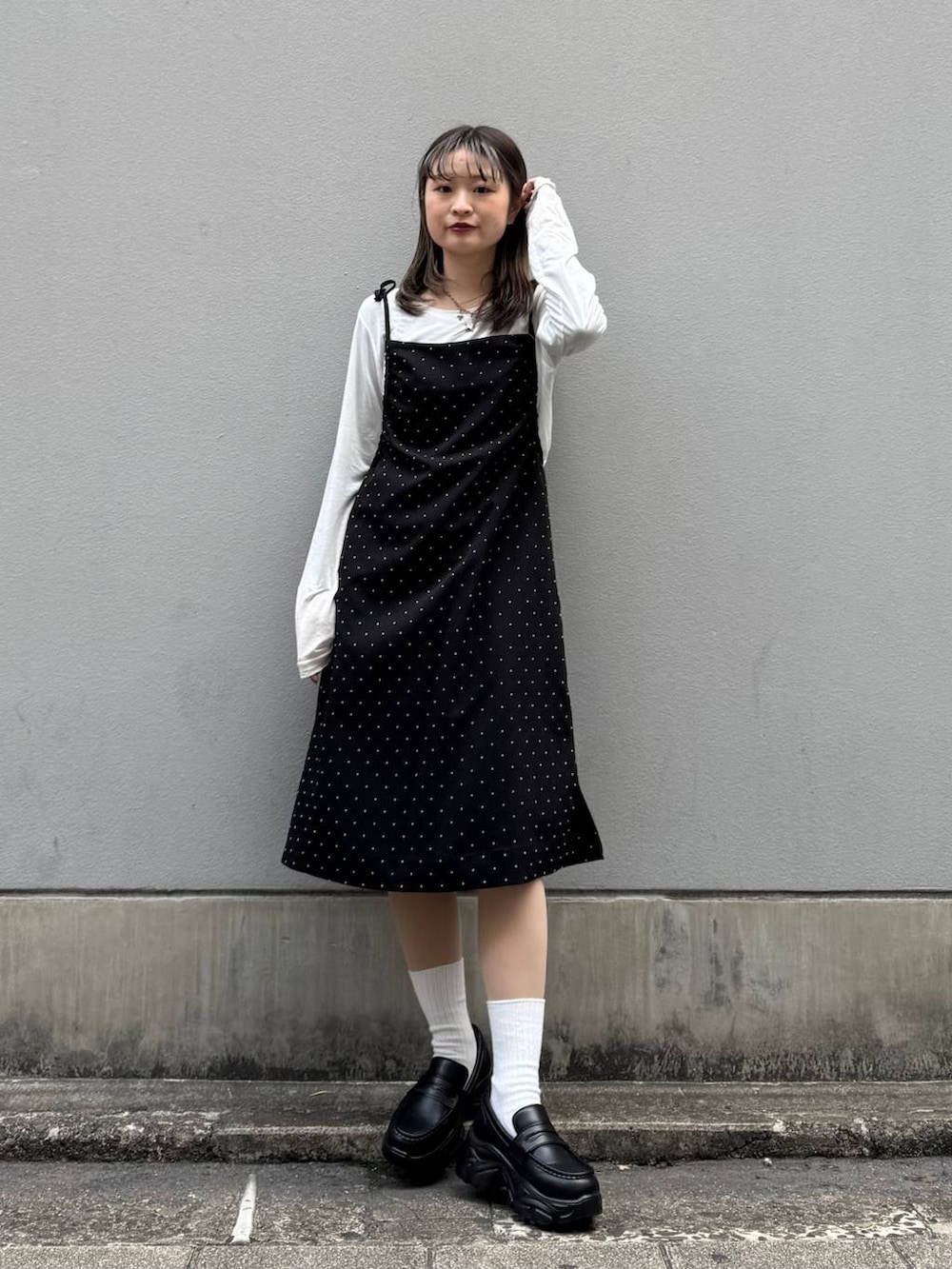 ブラック系のローファー、ブラック系のワンピース、ホワイト系のTシャツ/カットソーを着用したレディースの春コーディネートの3枚目の写真