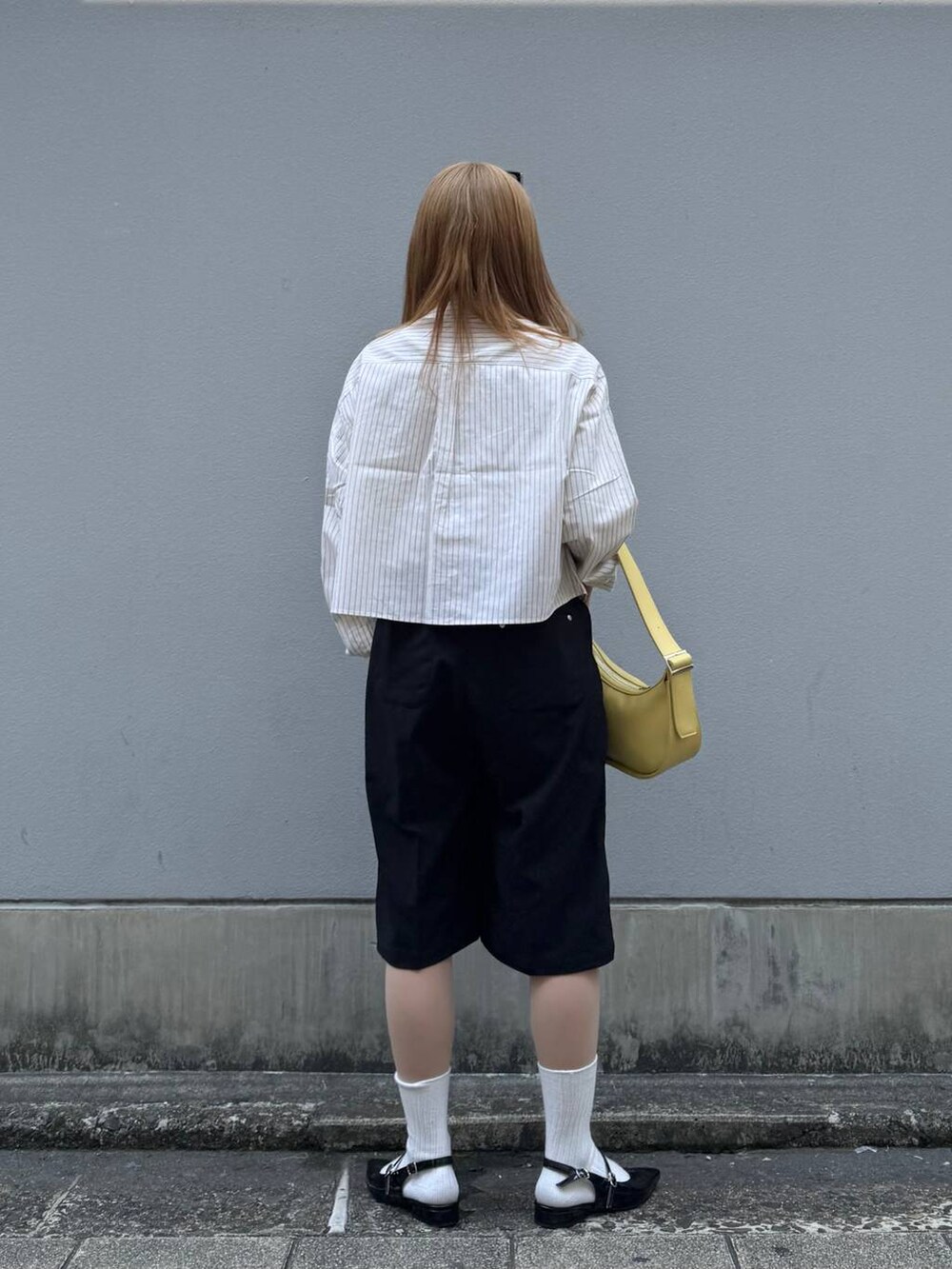 イエロー系のシャツ/ブラウス、ブラック系のパンプス、イエロー系のショルダーバッグを着用したレディースの春コーディネートの7枚目の写真