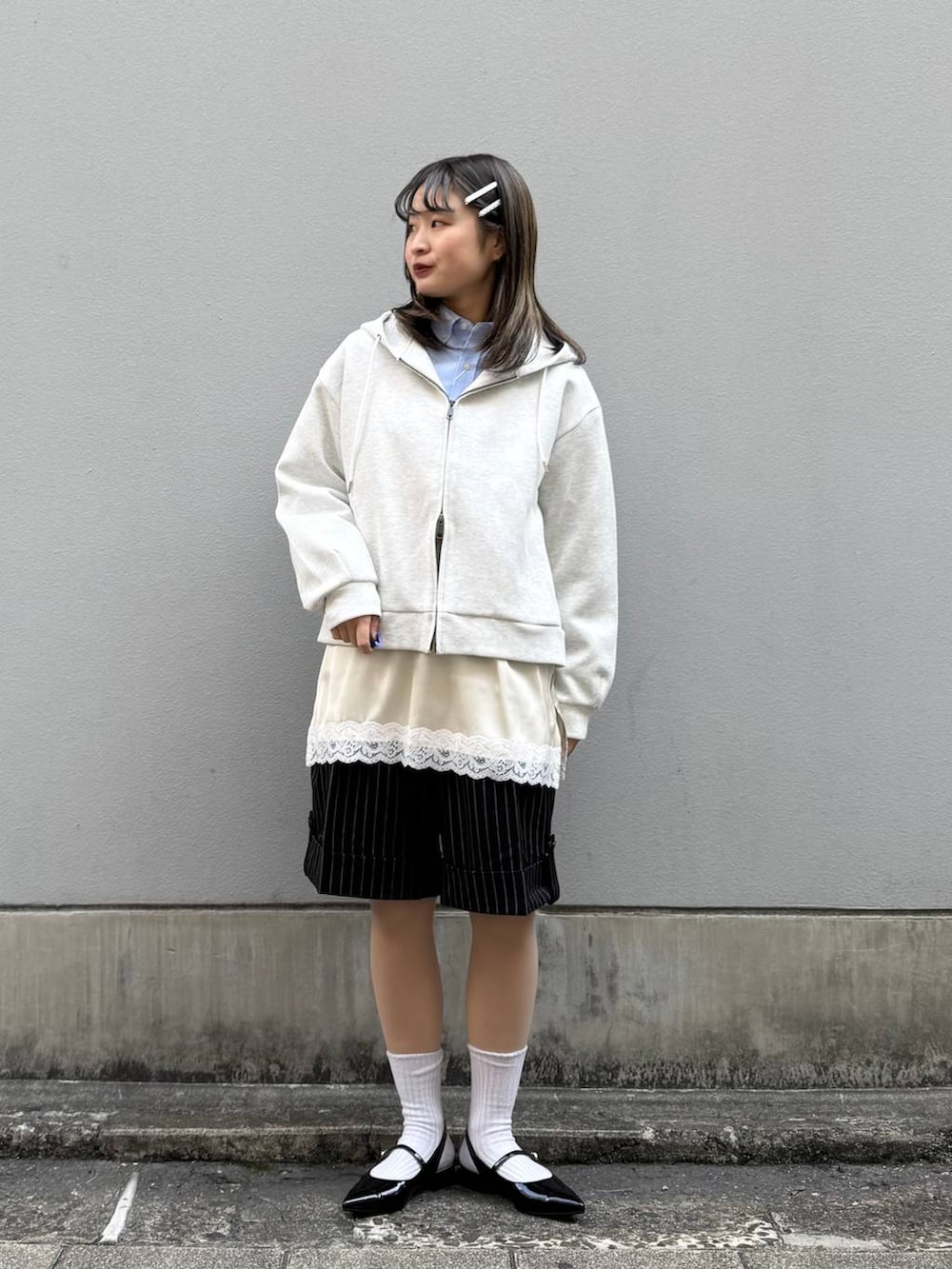 ブルー系のシャツ/ブラウス、ブラック系のパンプス、ホワイト系のパーカーを着用したレディースの春コーディネートの3枚目の写真