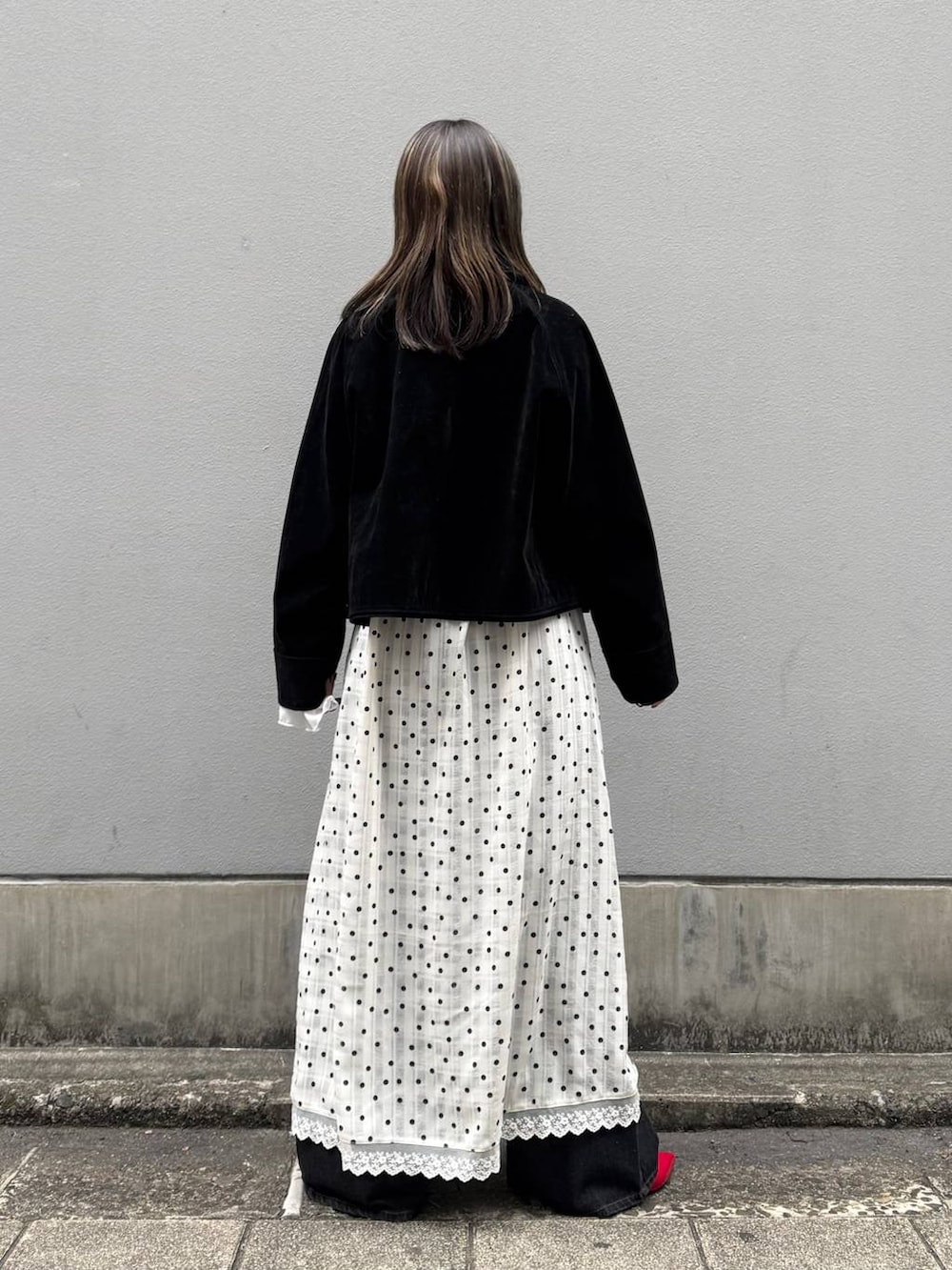 レッド系のパンプス、ブラック系のデニムパンツ、ブラック系のブルゾンを着用したレディースの春コーディネートの5枚目の写真