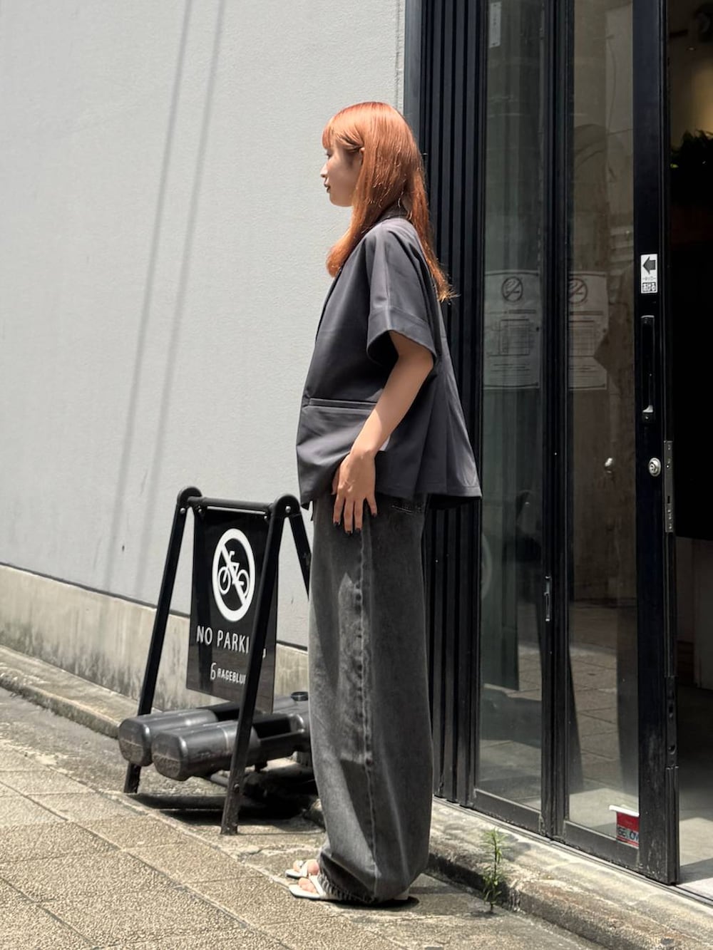 グレー系のデニムパンツ、グレー系のテーラードジャケット、ホワイト系のキャミソールを着用したレディースの夏コーディネートの4枚目の写真