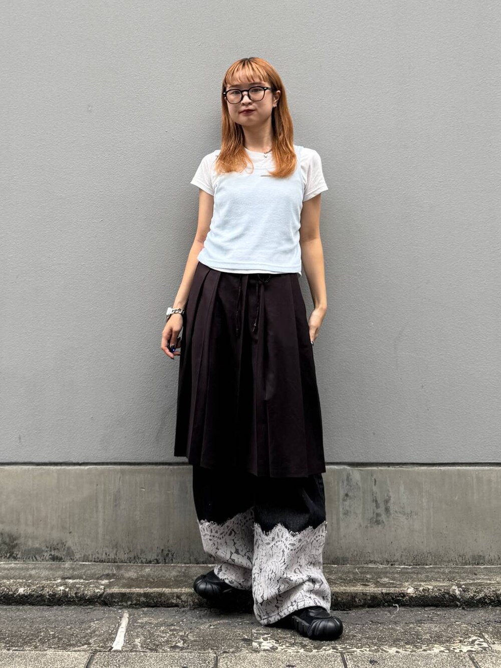 ブラウン系のスカート、ブラック系のデニムパンツ、ホワイト系のTシャツ/カットソーを着用したレディースの秋コーディネートの5枚目の写真