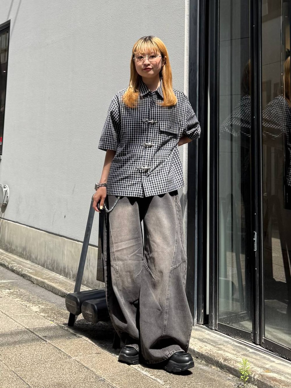 ブラック系のデニムパンツ、ブルー系のシャツ/ブラウス、グレー系のサングラスを着用したレディースの夏コーディネートの2枚目の写真