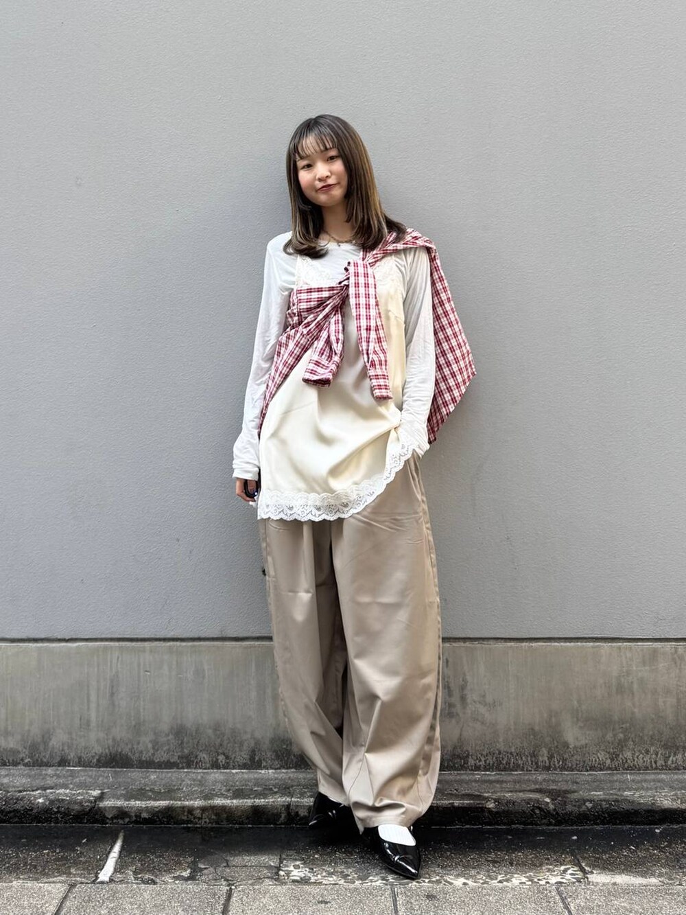 ブラック系のパンプス、ホワイト系のキャミソール、ベージュ系のスラックスを着用したレディースの春コーディネートの6枚目の写真