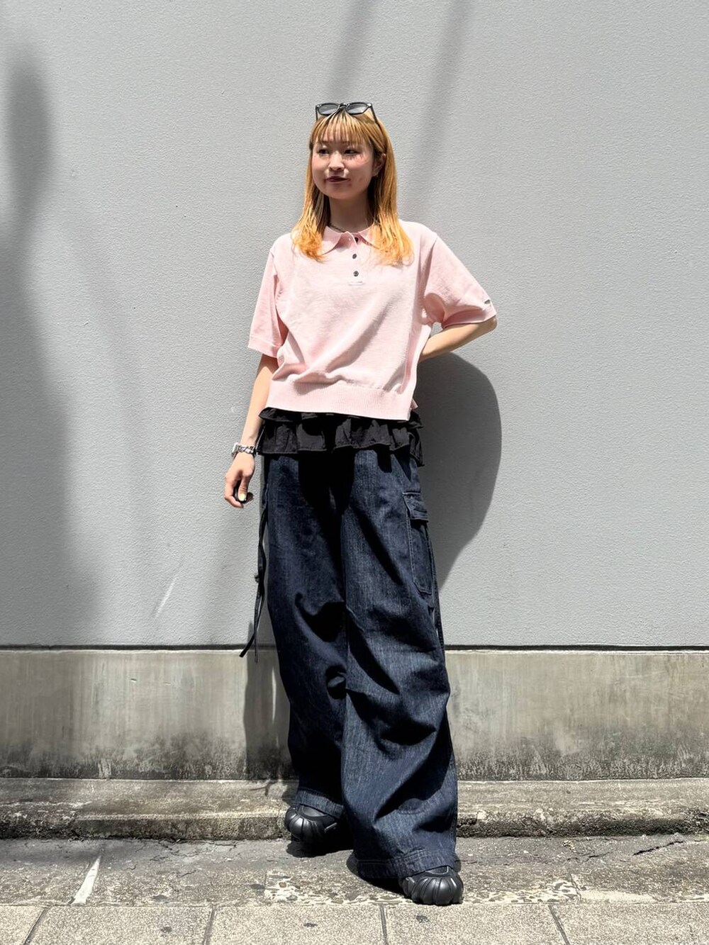 ピンク系のポロシャツ、ブルー系のデニムパンツ、グレー系のタンクトップを着用したレディースの夏コーディネートの4枚目の写真
