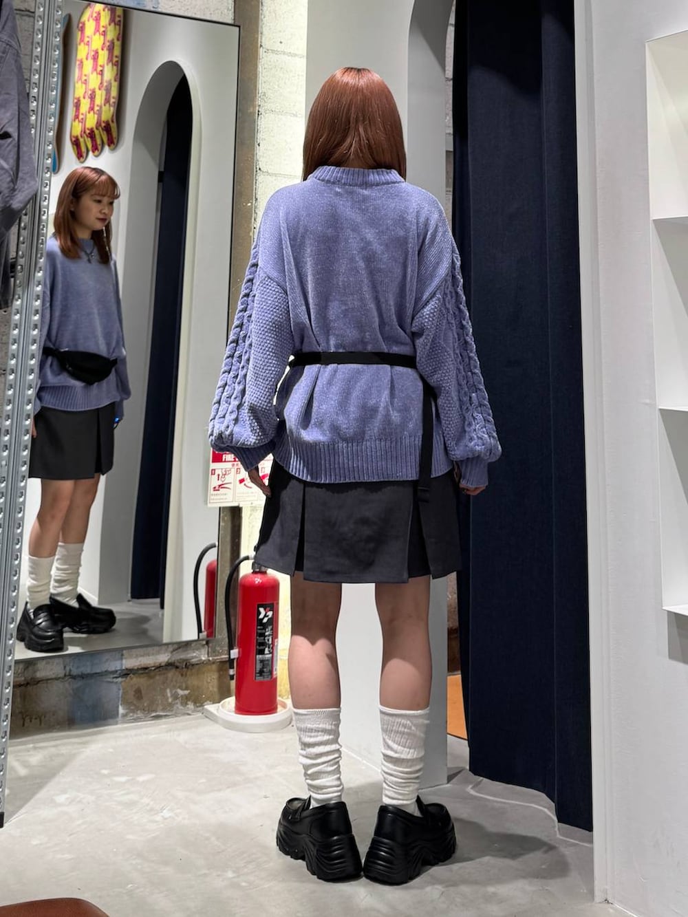 ブルー系のニット/セーター、グレー系のスカート、ブラック系のボディバッグ/ウエストポーチを着用したレディースの秋コーディネートの6枚目の写真