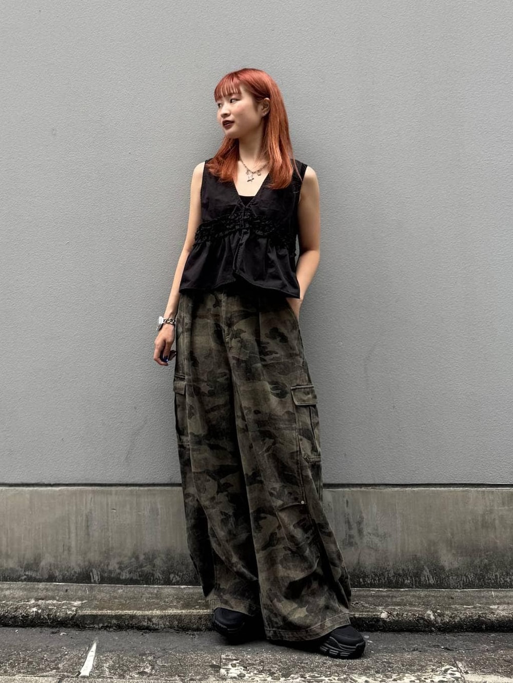 グリーン系のカーゴパンツ、ブラック系のタンクトップ、ブラック系のサンダルを着用したレディースの夏コーディネートの4枚目の写真