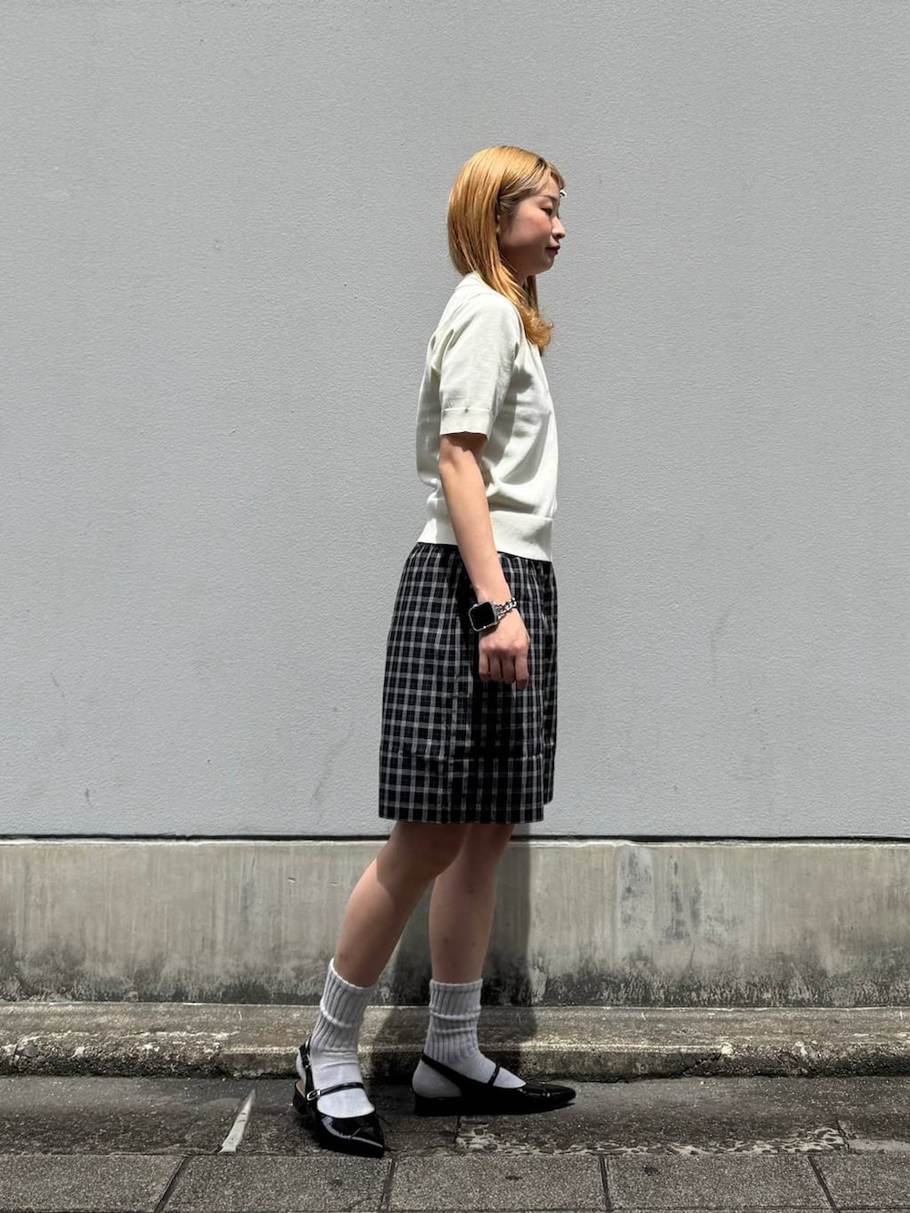 ブラック系のパンプス、ブラック系のその他パンツ、ホワイト系のポロシャツを着用したレディースの春コーディネートの8枚目の写真