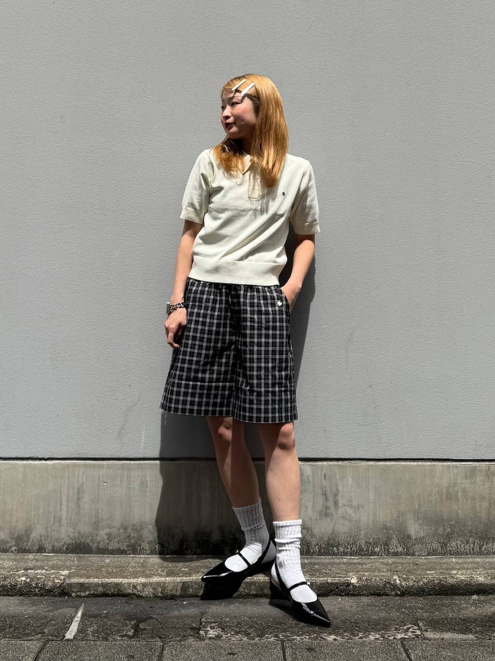 ブラック系のパンプス、ブラック系のその他パンツ、ホワイト系のポロシャツを着用したレディースの春コーディネートの2枚目の写真