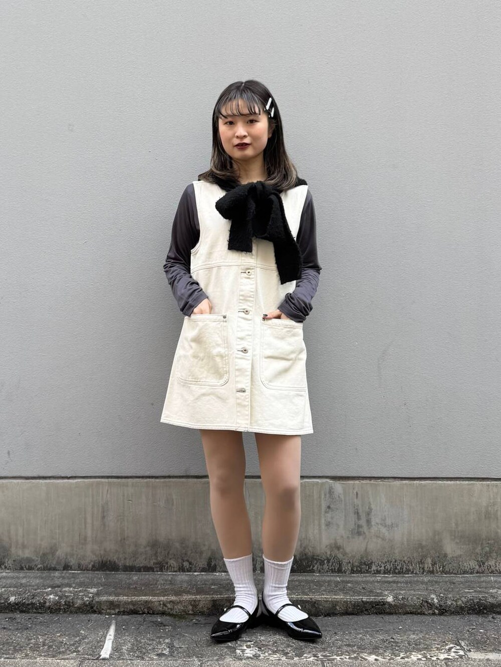 ブラック系のパンプス、ホワイト系のワンピース、グレー系のTシャツ/カットソーを着用したレディースの春コーディネートの3枚目の写真