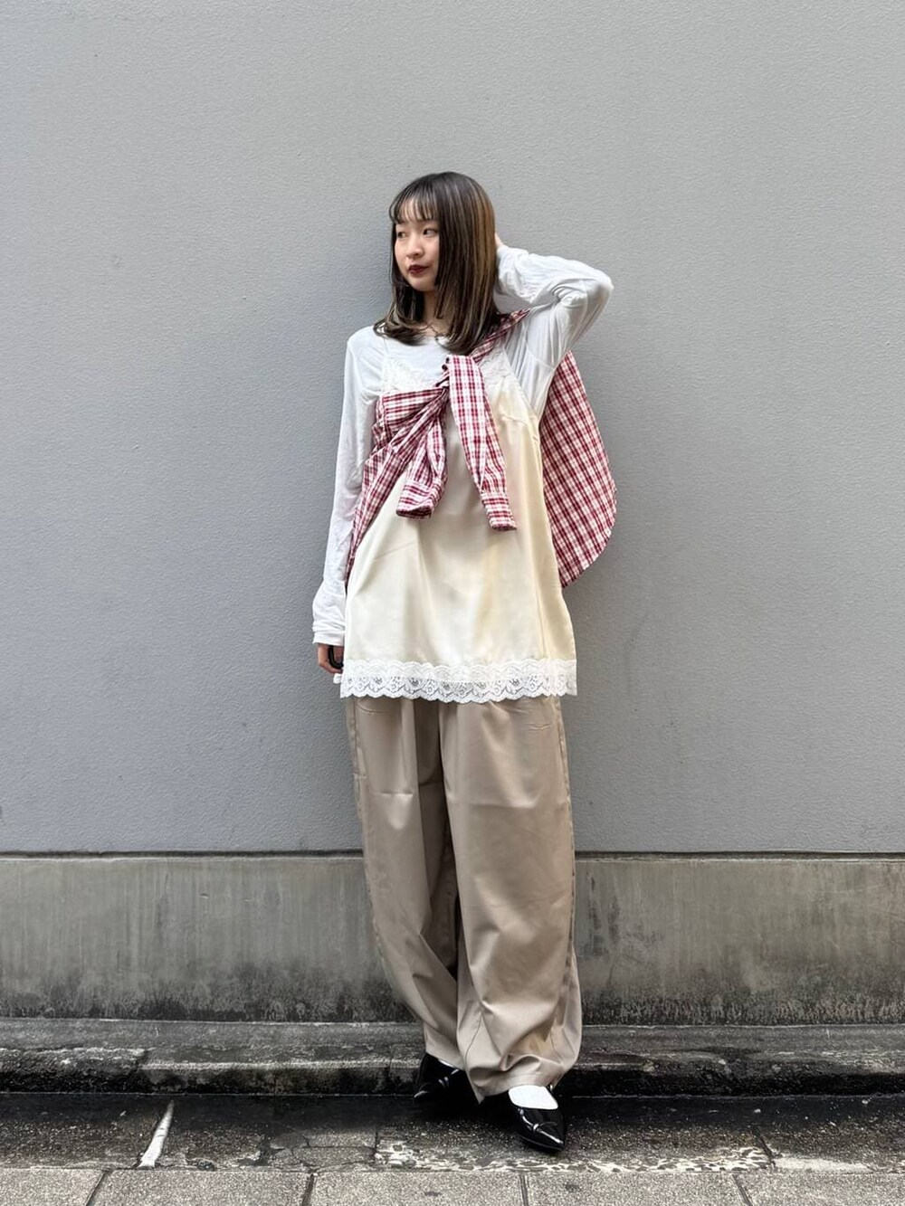 ブラック系のパンプス、ホワイト系のキャミソール、ベージュ系のスラックスを着用したレディースの春コーディネートの2枚目の写真