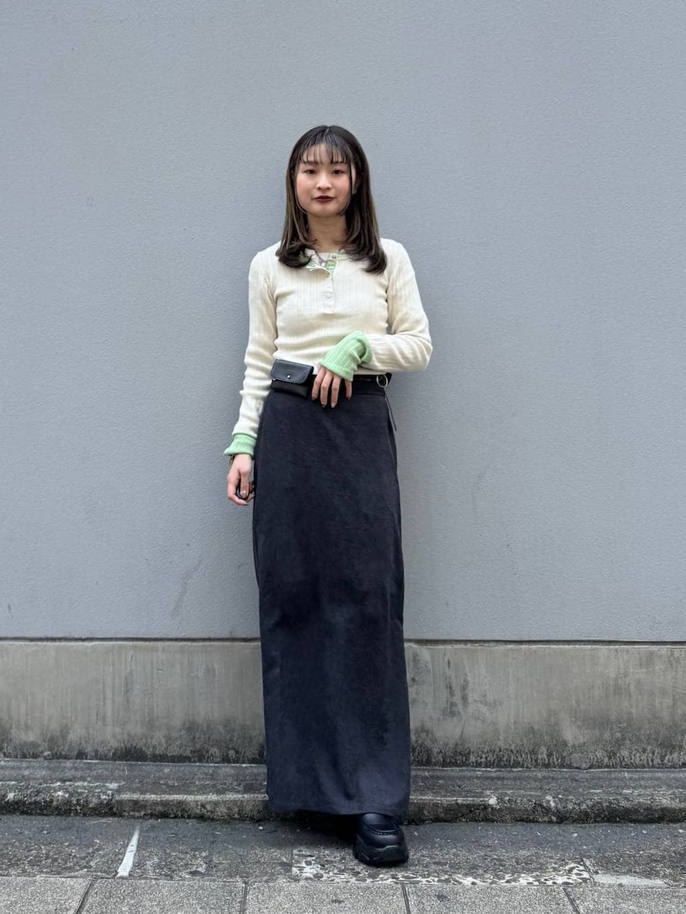 ブラック系のローファー、ブラック系のスカート、ホワイト系のニット/セーターを着用したレディースの春コーディネートの3枚目の写真