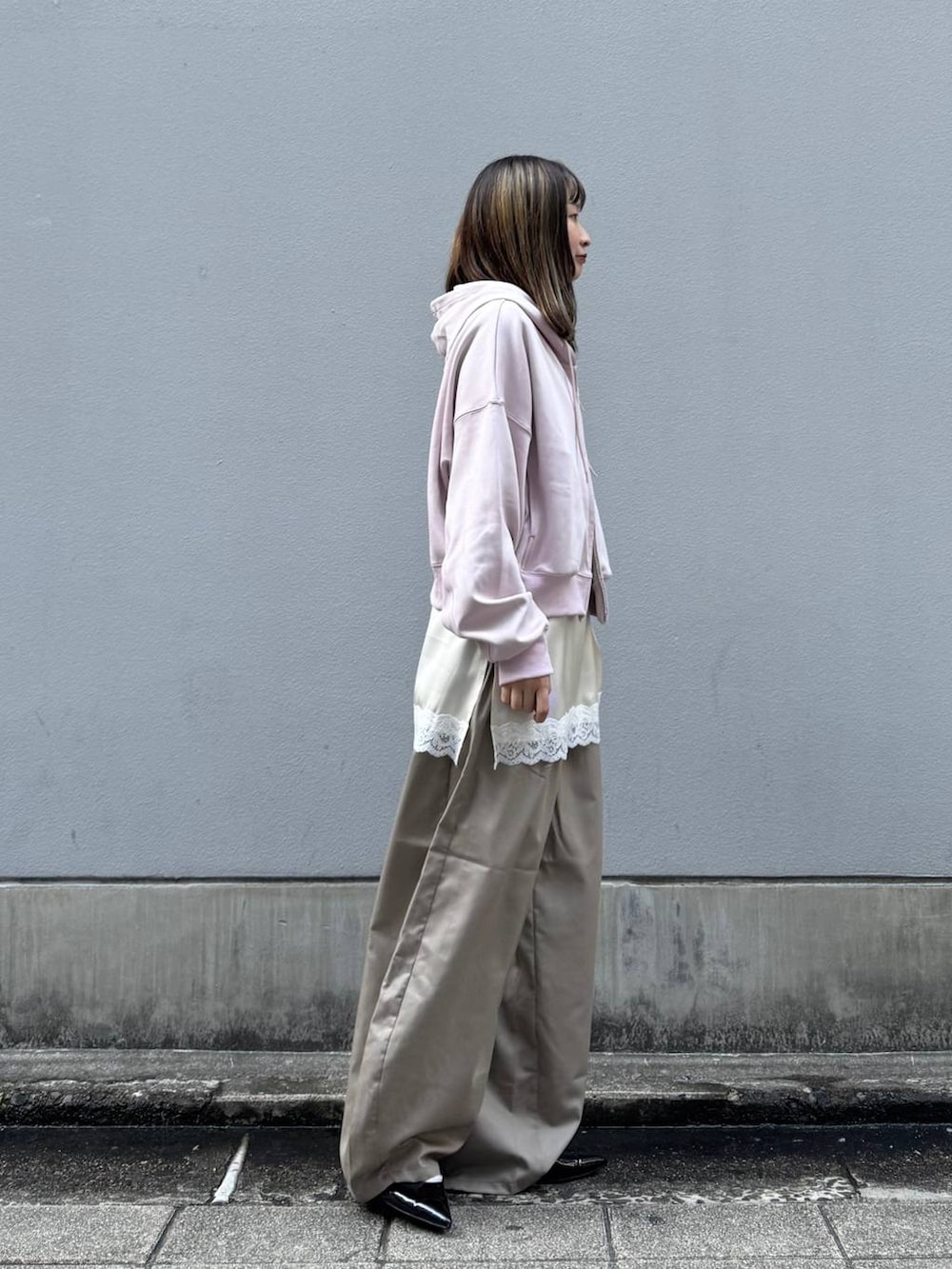 ブラック系のパンプス、ホワイト系のキャミソール、ベージュ系のスラックスを着用したレディースの春コーディネートの7枚目の写真