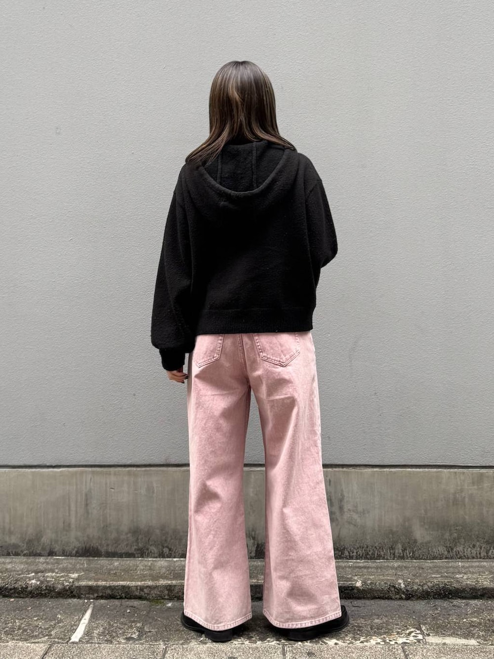 ピンク系のデニムパンツ、ブラック系のニット/セーターを着用したレディースの春コーディネートの6枚目の写真