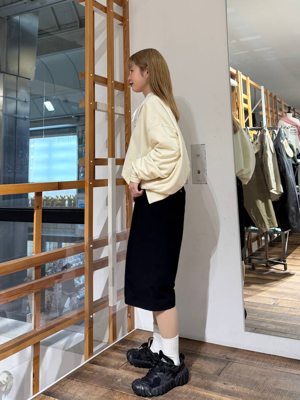 ホワイト系のスウェット、ブラック系のスラックスを着用したレディースの春コーディネートの5枚目の写真
