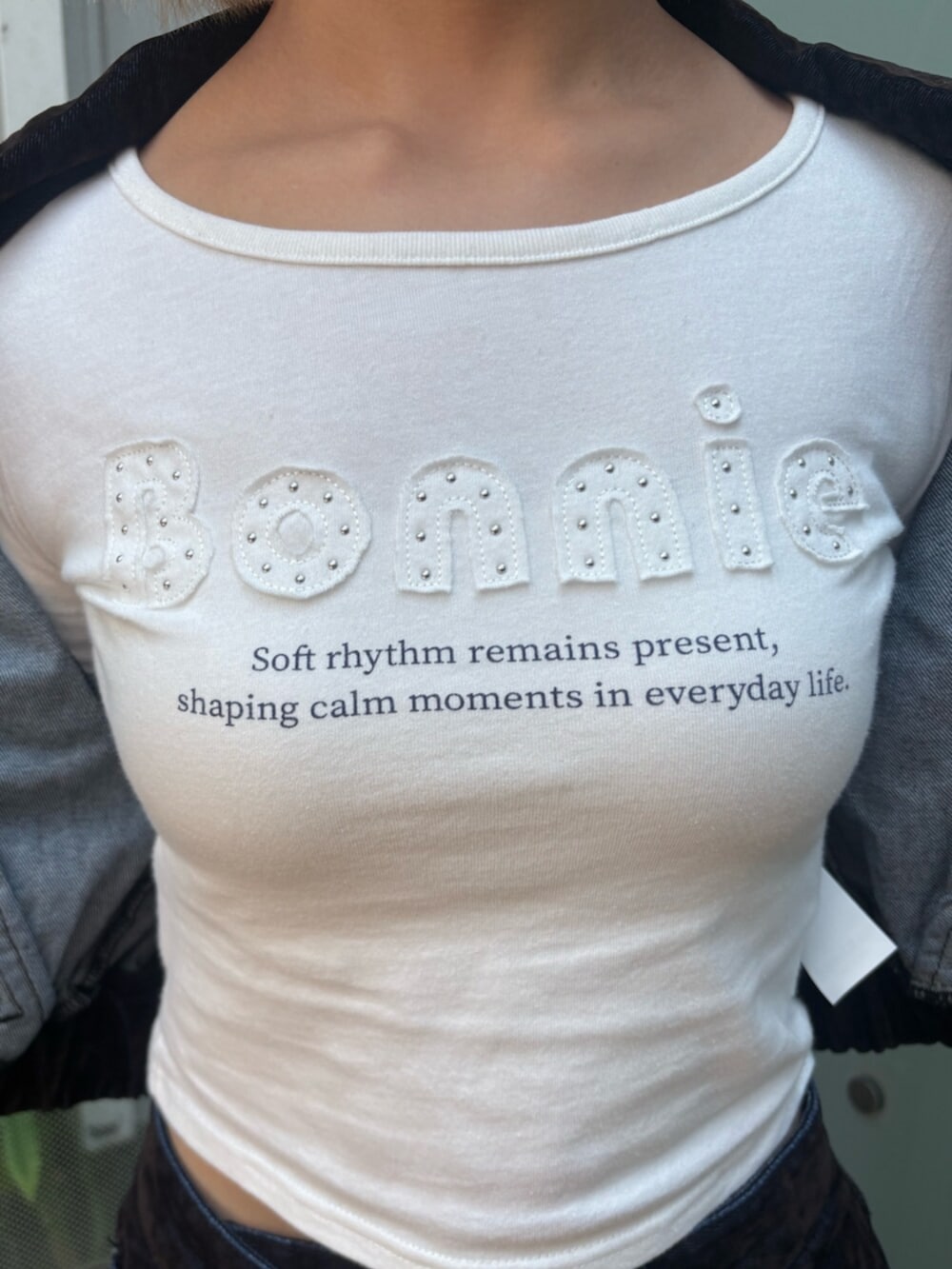 ホワイト系のTシャツ/カットソー、ブラウン系のブルゾン、ブラウン系のスカートを着用したレディースの秋コーディネートの4枚目の写真