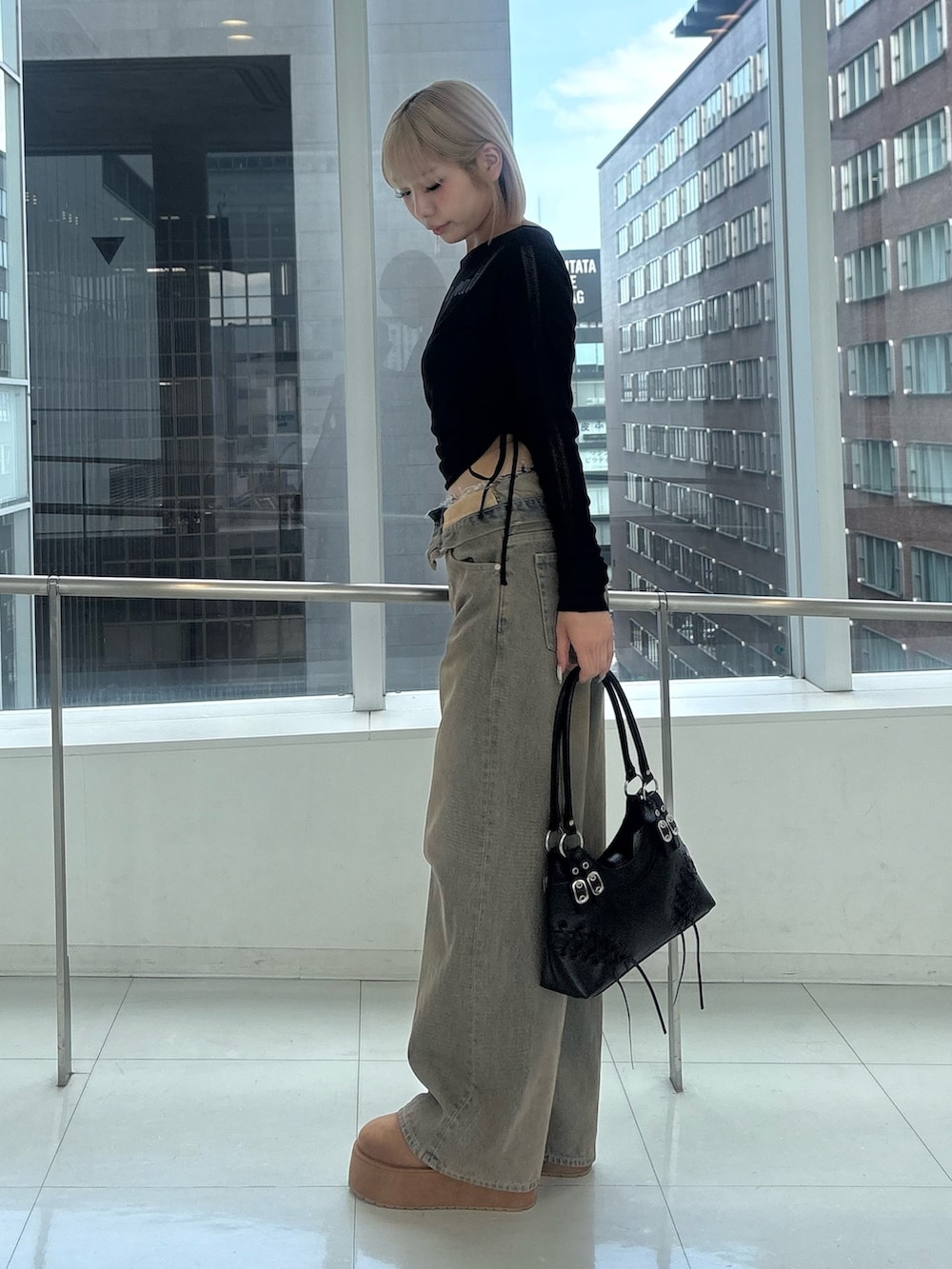 ブラック系のTシャツ/カットソー、ブラウン系のデニムパンツ、イエロー系のスリッポンを着用したレディースの秋コーディネートの2枚目の写真