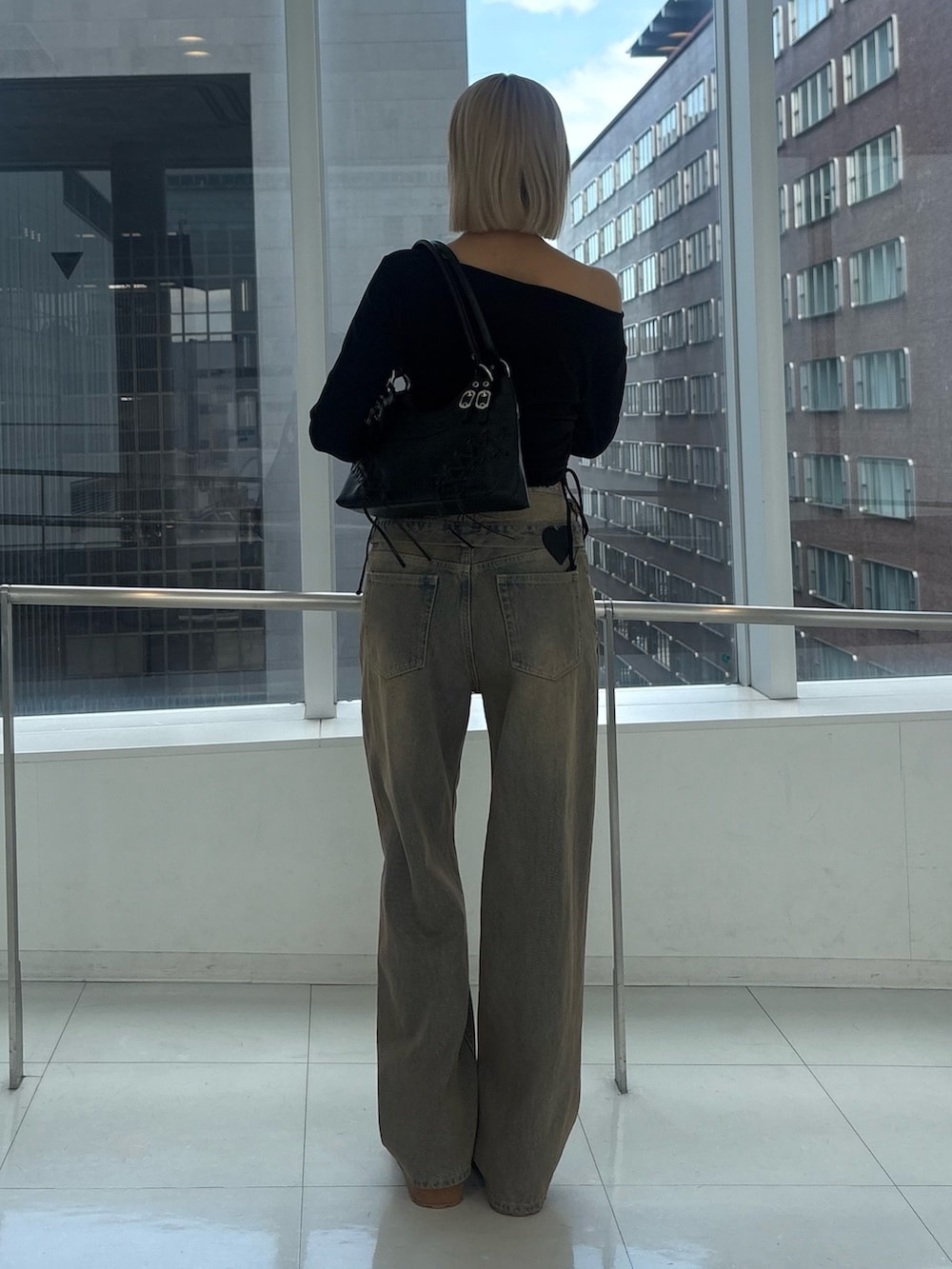 ブラック系のTシャツ/カットソー、ブラウン系のデニムパンツ、イエロー系のスリッポンを着用したレディースの秋コーディネートの3枚目の写真