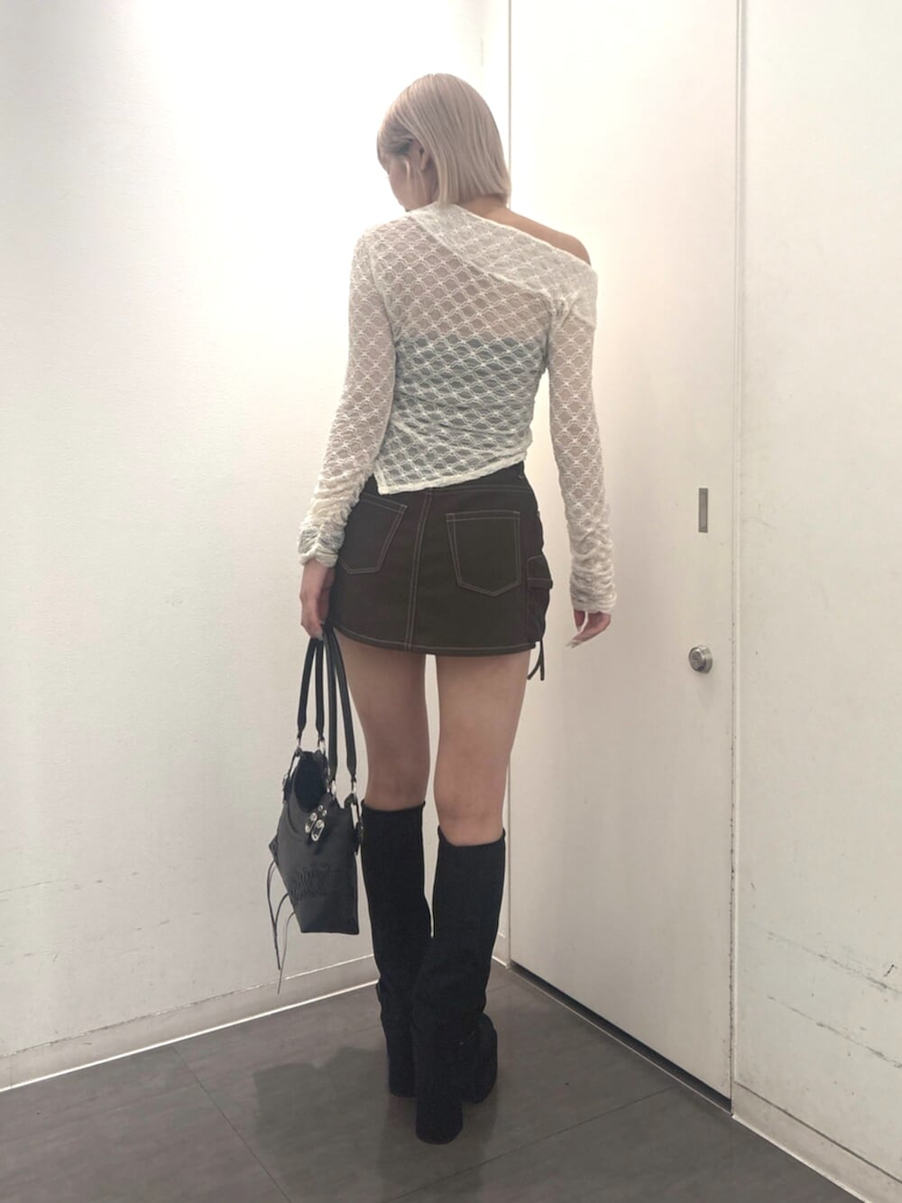 ブラック系のショルダーバッグ、ホワイト系のTシャツ/カットソー、ブラウン系のスカートを着用したレディースの秋コーディネートの3枚目の写真