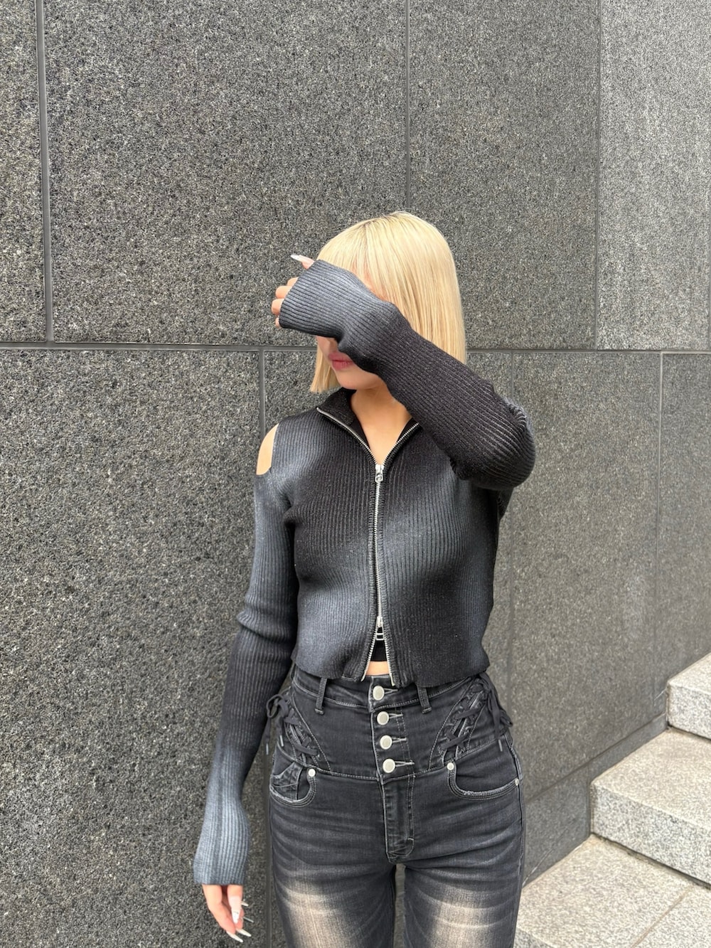 ブラック系のデニムパンツ、ブラック系のニット/セーター、ブラック系のブーツを着用したレディースの冬コーディネートの4枚目の写真