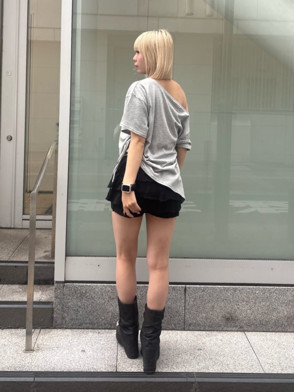 ブラック系のスカート、ブラック系のサンダル、グレー系のTシャツ/カットソーを着用したレディースの夏コーディネートの3枚目の写真