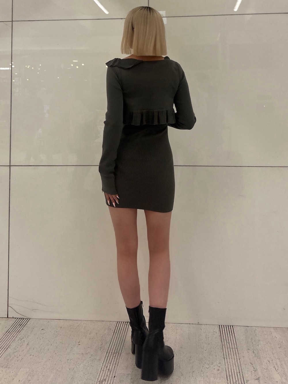 グレー系のワンピース、ブラック系のブーツを着用したレディースの冬コーディネートの3枚目の写真