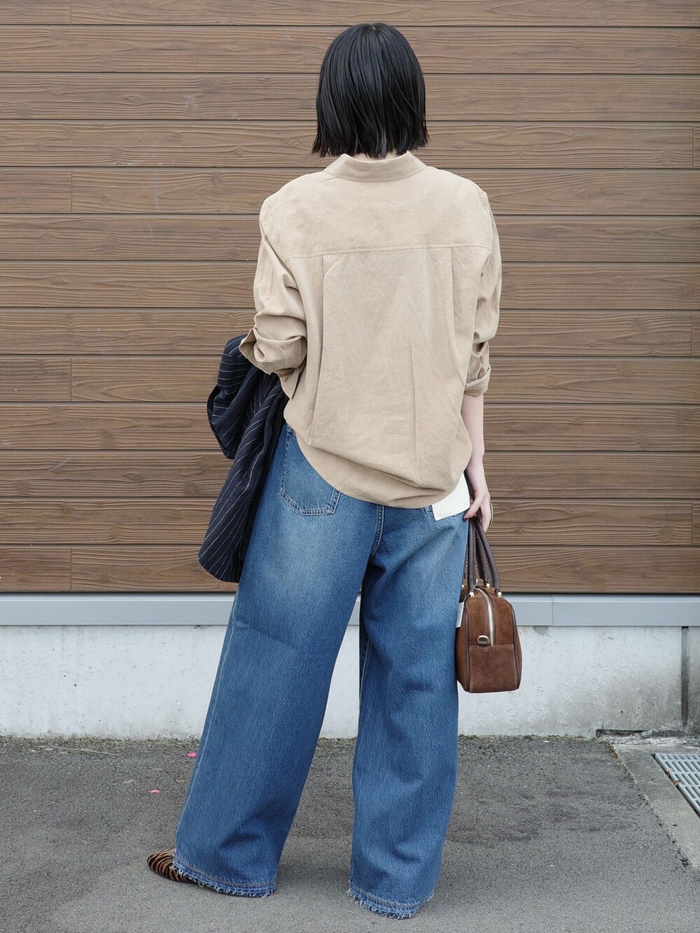 ブルー系のデニムパンツ、ベージュ系のシャツ/ブラウスを着用したレディースの春コーディネートの3枚目の写真