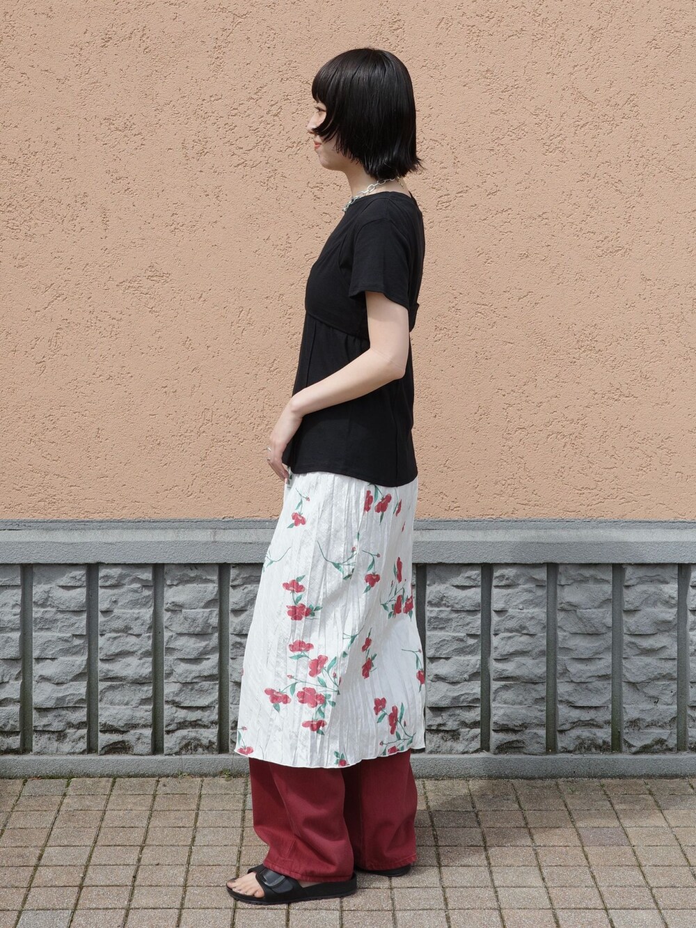 レッド系のその他パンツ、ホワイト系のスカート、ブラック系のTシャツ/カットソーを着用したレディースの夏コーディネートの3枚目の写真