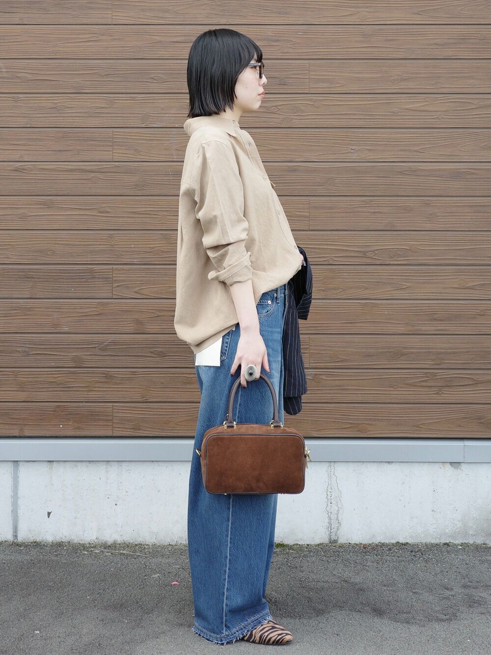 ブルー系のデニムパンツ、ベージュ系のシャツ/ブラウスを着用したレディースの春コーディネートの2枚目の写真
