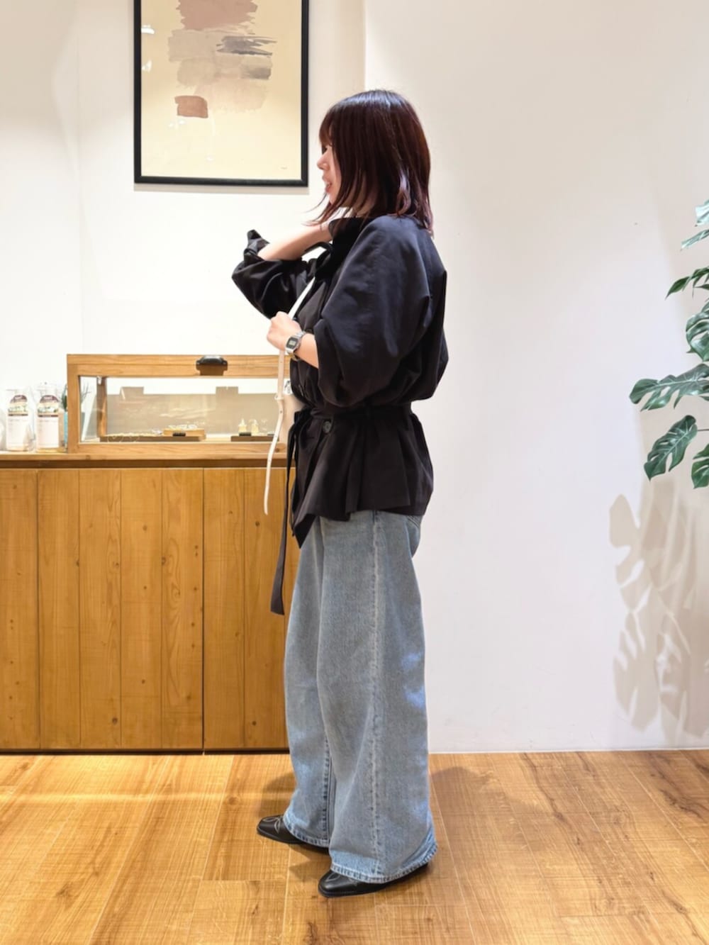 ブルー系のデニムパンツ、グレー系のトレンチコート、ブラック系のその他シューズを着用したレディースの秋コーディネートの2枚目の写真