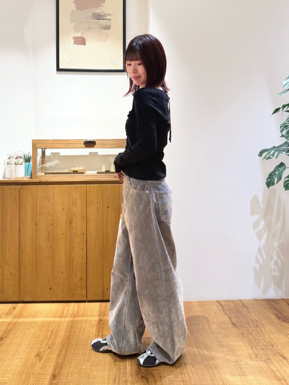 ブラック系のニット/セーター、ベージュ系のデニムパンツを着用したレディースの秋コーディネートの2枚目の写真