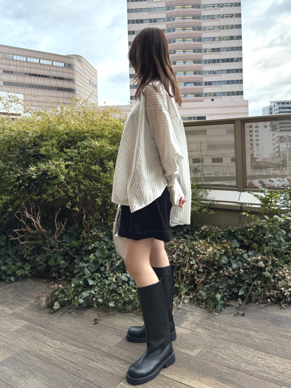 ホワイト系のシャツ/ブラウス、ブラック系のその他パンツ、ブラック系のブーツを着用したレディースの春コーディネートの2枚目の写真