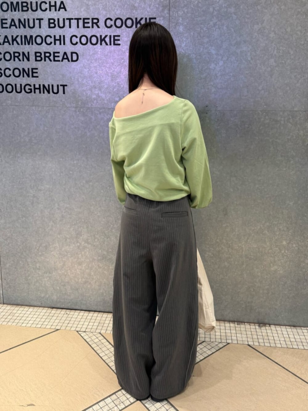 グリーン系のTシャツ/カットソー、グレー系のその他パンツ、ホワイト系のトートバッグを着用したレディースの冬コーディネートの3枚目の写真