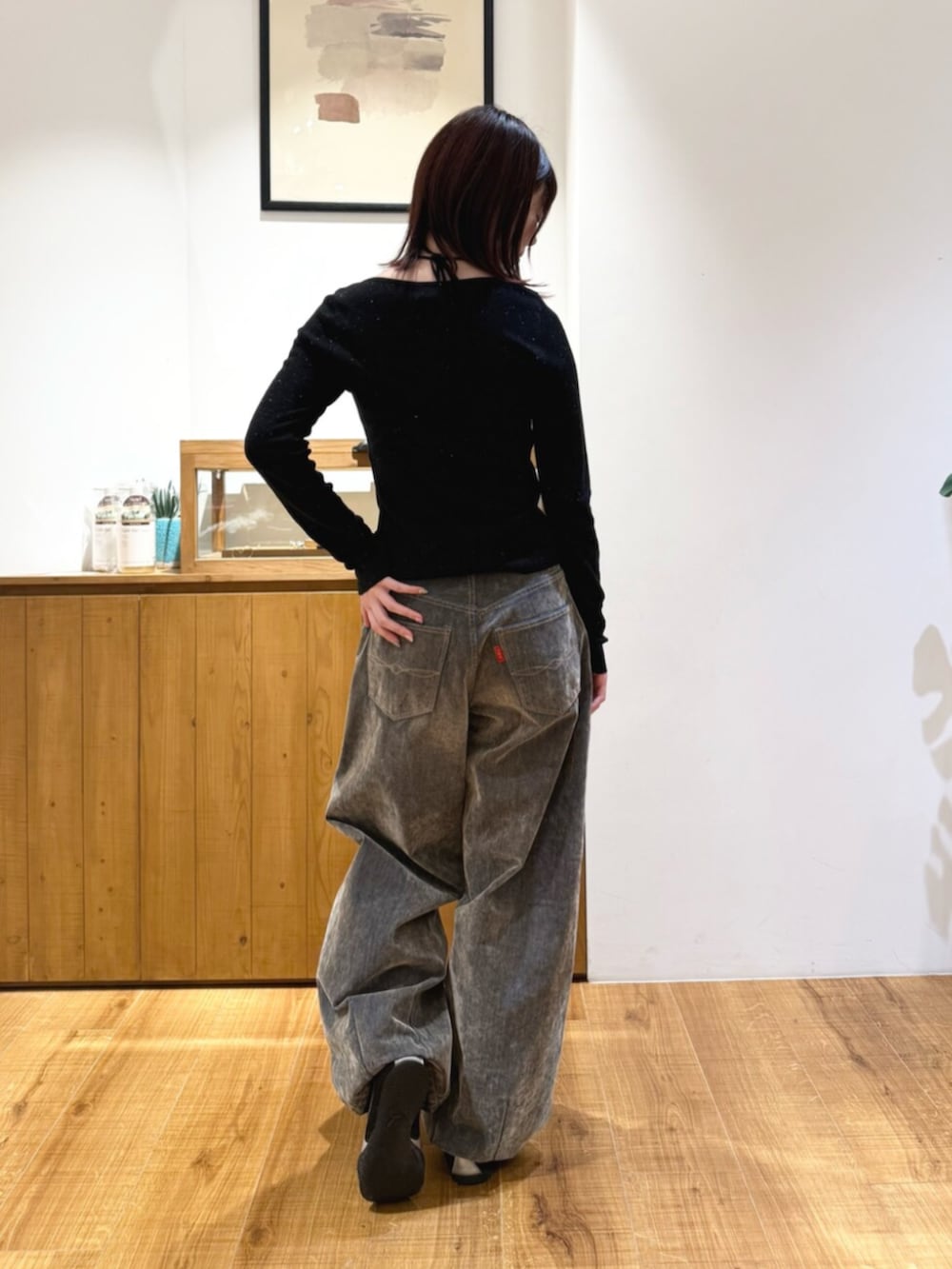 ブラック系のニット/セーター、ベージュ系のデニムパンツを着用したレディースの秋コーディネートの3枚目の写真