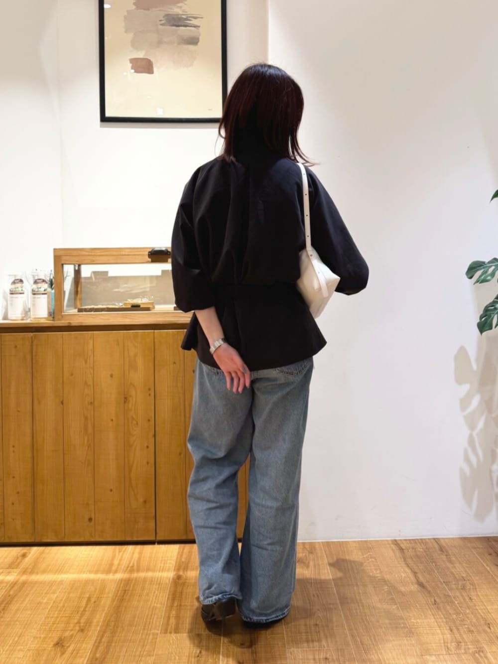 ブルー系のデニムパンツ、グレー系のトレンチコート、ブラック系のその他シューズを着用したレディースの秋コーディネートの3枚目の写真