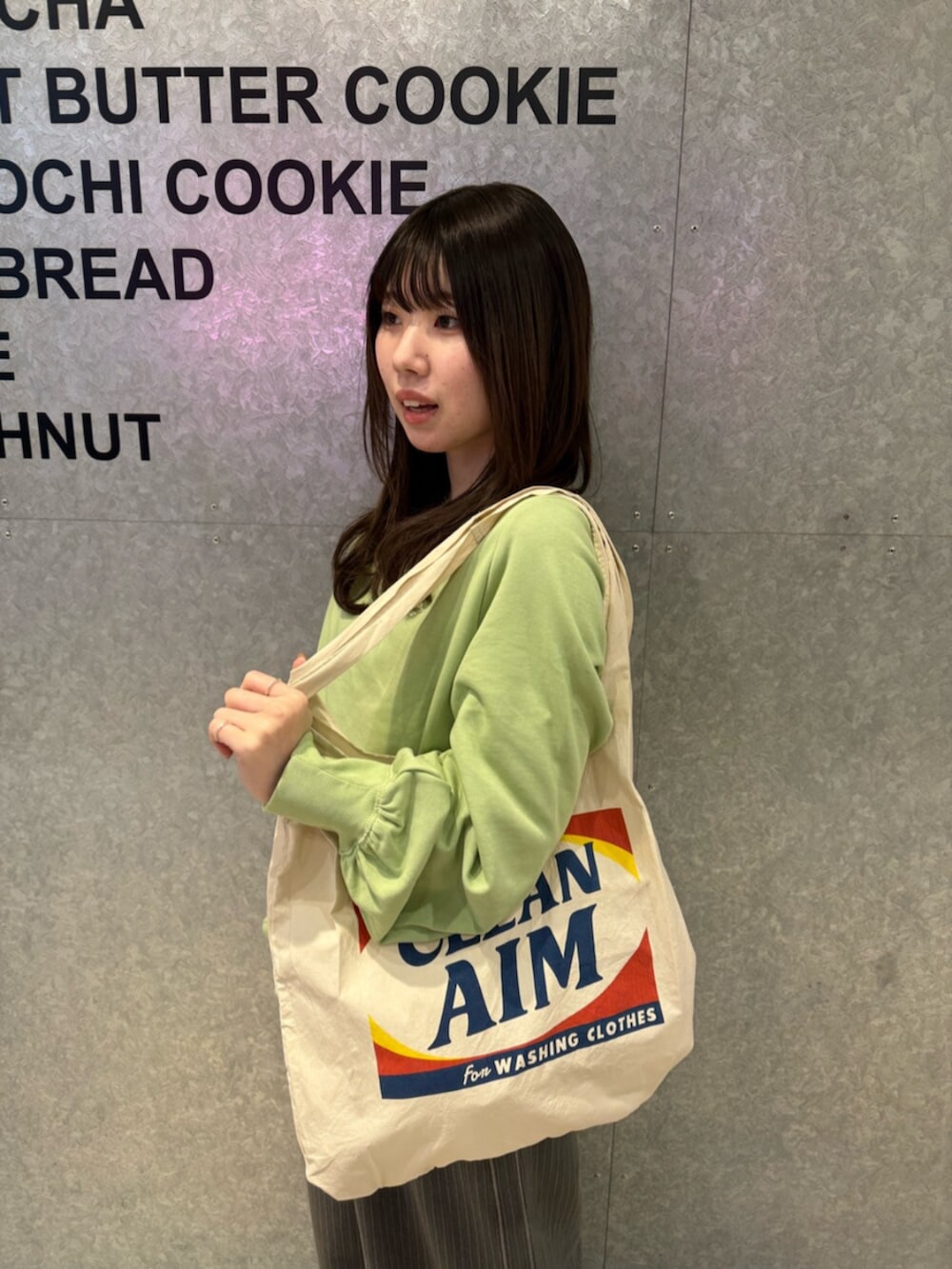グリーン系のTシャツ/カットソー、グレー系のその他パンツ、ホワイト系のトートバッグを着用したレディースの冬コーディネートの5枚目の写真