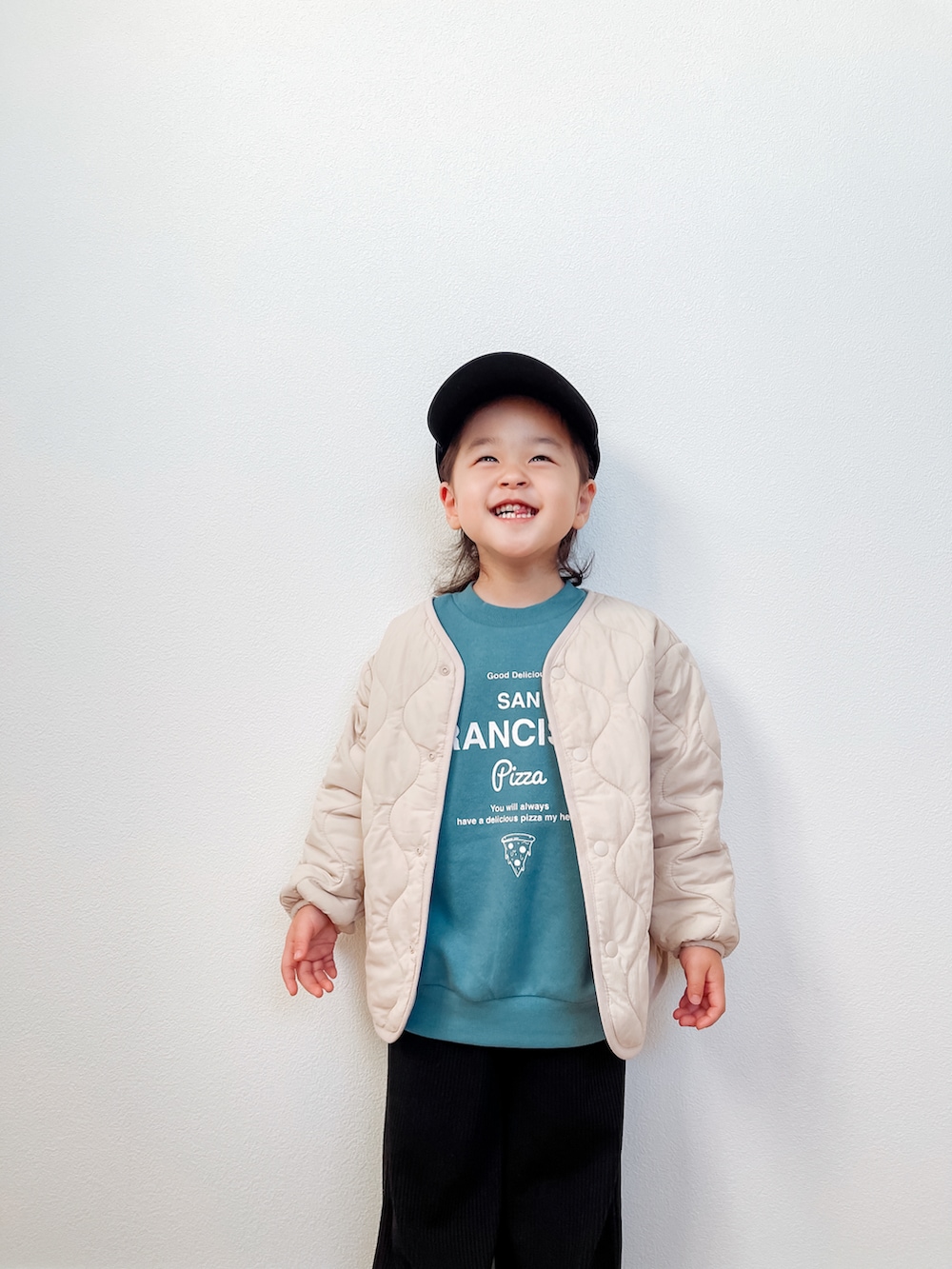 ベージュ系のジャケット/アウター、ブルー系のトップス、ブラック系のオールインワン・サロペットを着用したキッズの冬コーディネートの2枚目の写真