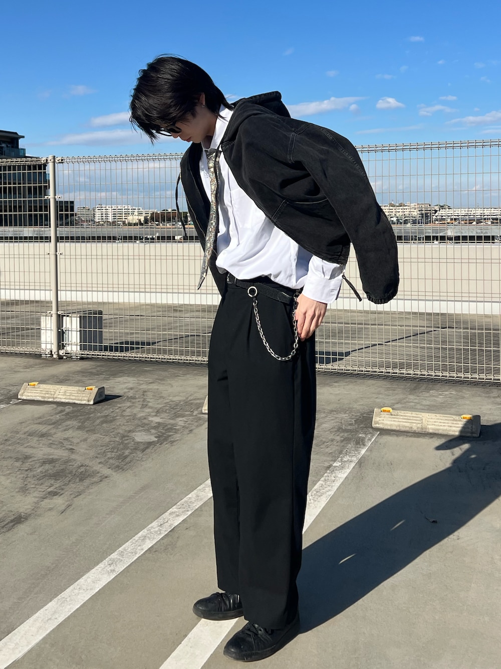 ブラック系のパンツ、ブラック系のパーカー、ベージュ系のファッション雑貨を着用したメンズの冬コーディネートの5枚目の写真